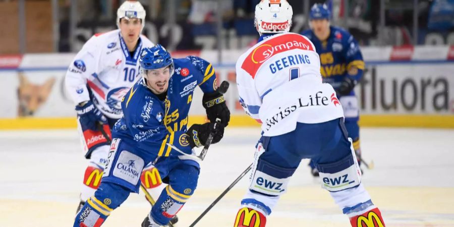 Marc Wieser vom HC Davos kämpft sich gegen Patrick Geering von den ZSC Lions durch.