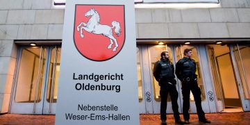Polizisten stehen vor den Weser-Ems-Hallen zum Prozessauftakt gegen den wegen vielfachen Mordes Angeklagten Niels Högel.