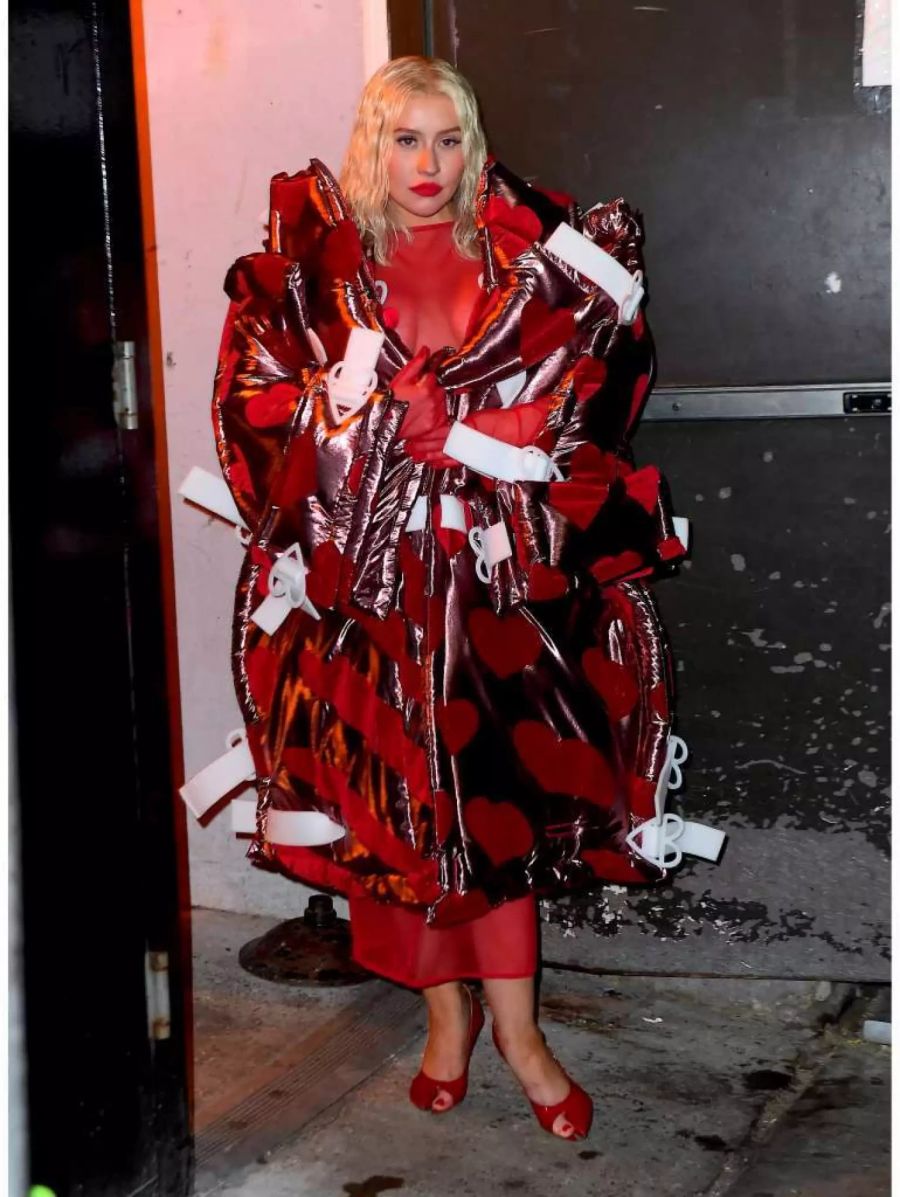 Christina Aguilera in einem roten Riesenmantel an der New York Fashion Week.