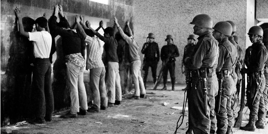 Auf diesem Foto bewachen mexikanische Soldaten 1968 eine Gruppe junger Männer.