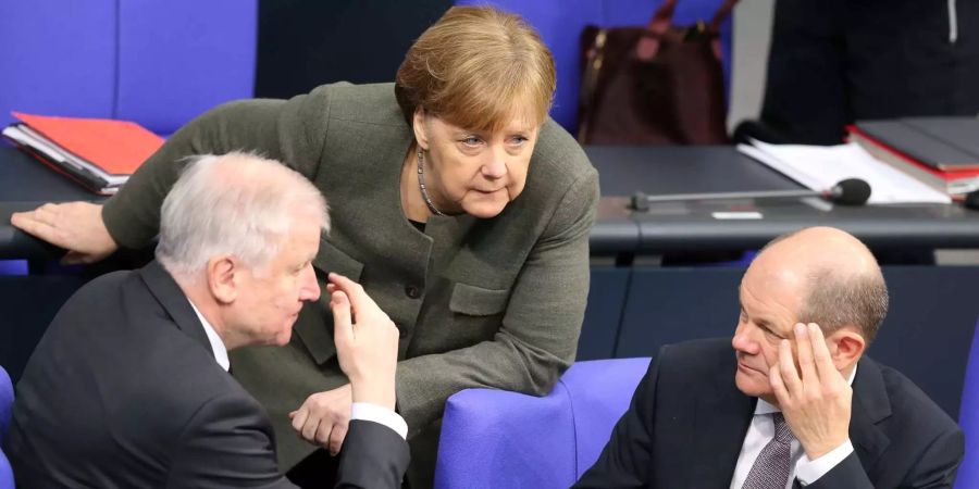 Bundeskanzlerin Angela Merkel (CDU) unterhält sich im Deutschen Bundestag mit Bundesinnenminister Horst Seehofer (CSU), und mit Bundesfinanzminister Olaf Scholz (SPD).