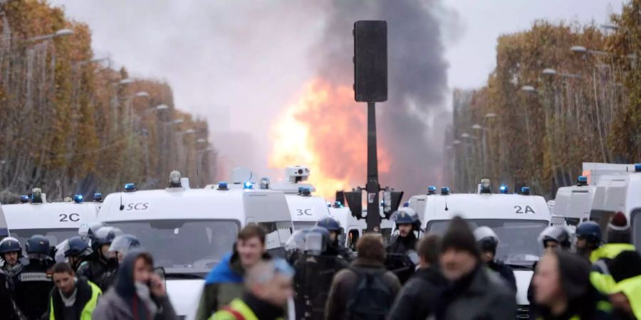 Ein Feuerball ist zu sehen, nachdem Demonstranten einen Bauwagen in Brand gesetzt haben.