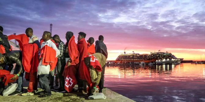 Einwanderer aus Nordafrika stehen am Hafen von Malaga.