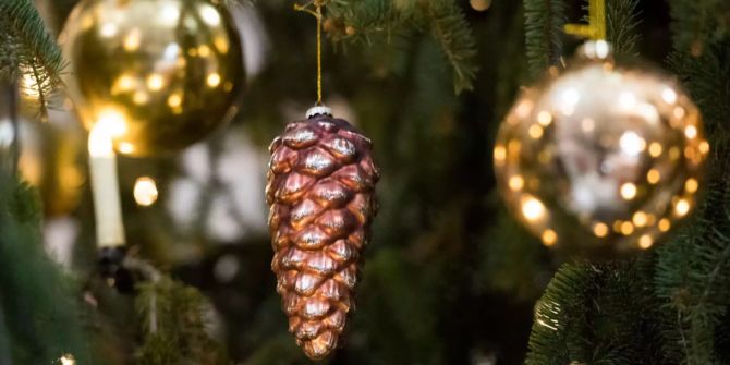 Weihnachtsdekoration hängt an einem Tannenbaum.