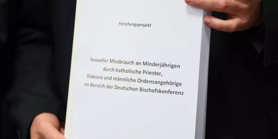 Stephan Ackermann, Bischof von Trier und Beauftragter für Fragen des sexuellen Missbrauchs im kirchlichen Bereich, hält zu Beginn einer Pressekonferenz der Deutschen Bischofskonferenz ein Exemplar der Studie "Sexueller Missbrauch an Minderjährigen durch katholische Priester, Diakone und männliche Ordensangehörige im Bereich der Deutschen Bischofskonferenz".