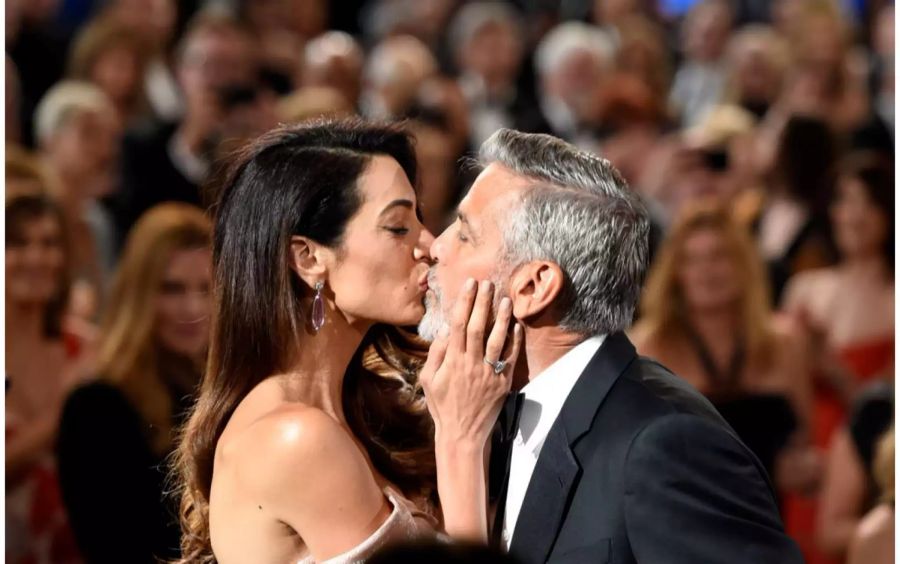 George und Amal Clooney küssen sich im Juni 2018 im Dolby Theater in Los Angeles vor Publikum.