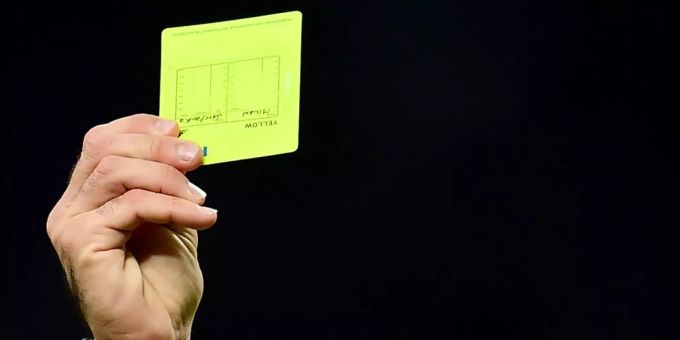 Schiedsrichter in Griechenland streiken. (Symbolbild) Ein Schiedsrichter hält die gelbe Karte hoch.