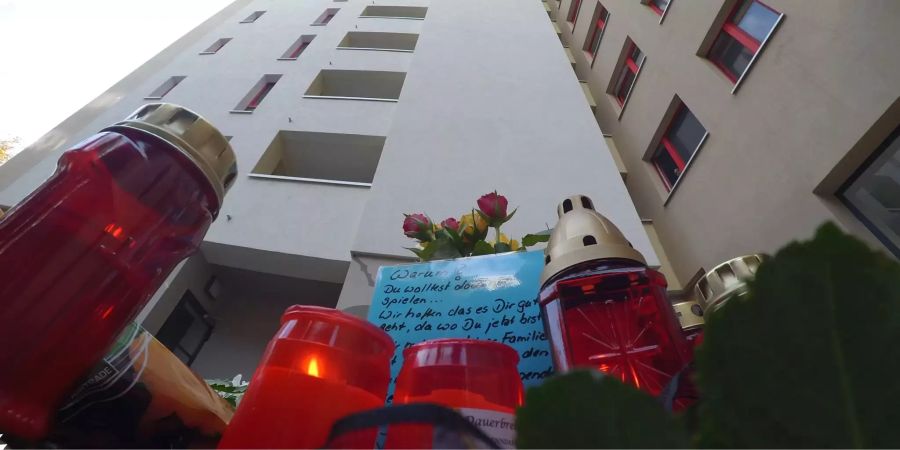 Blumen, Kerzen und Karten wurden vor einem Hochhaus abgelegt. Dort wurde am 14.10.2018 ein achtjähriger Junge von einem Baumstumpf erschlagen.