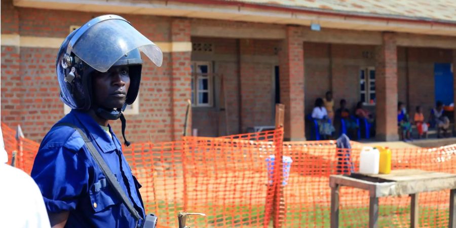 Ein Polizist steht vor einem neu errichteten Ebola Response Center im Kongo Wache.