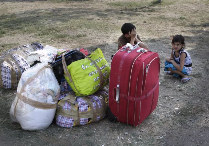 Kinder der Roma warten vor ihren gepackten Koffern und Taschen. roma