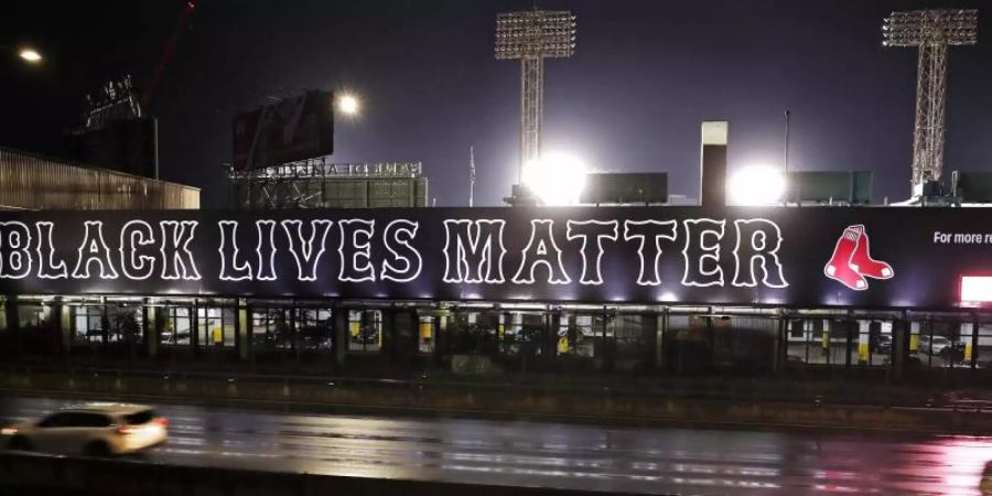 Ein Plakat mit der Aufschrift «Black Lives Matter» hängt am Fenway Park in Boston. Baseball-Profis dürfen in der kommenden MLB-Saison ihre Unterstützung für die Black-Lives-Matter-Bewegung zeigen. Foto: Charles Krupa/AP/dpa