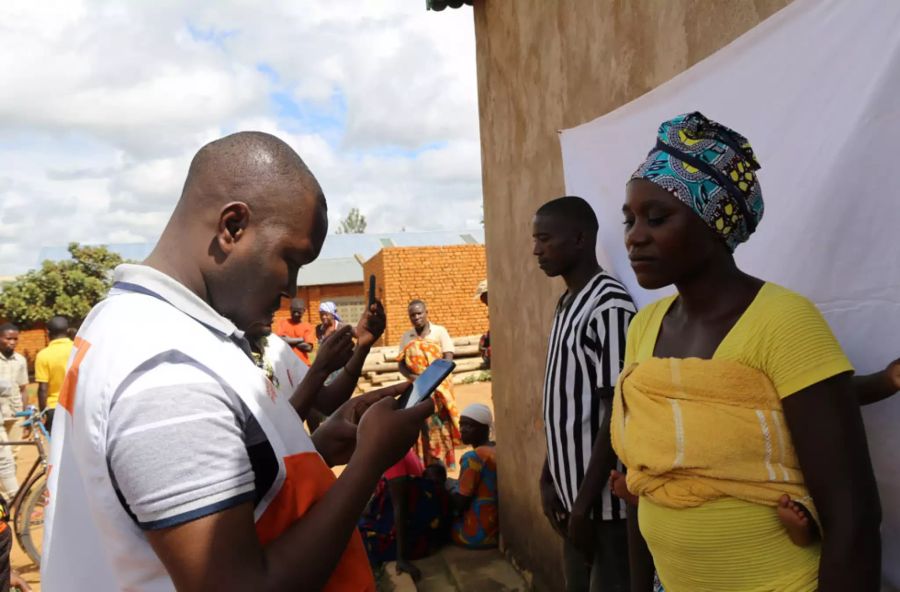 Mann mit Smartphone und Frau in Burundi