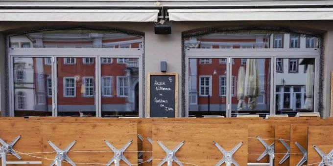 Hochgeklappte Tische stehen in einer Fussgängerzone vor einer Gastwirtschaft . Gastwirtschaft