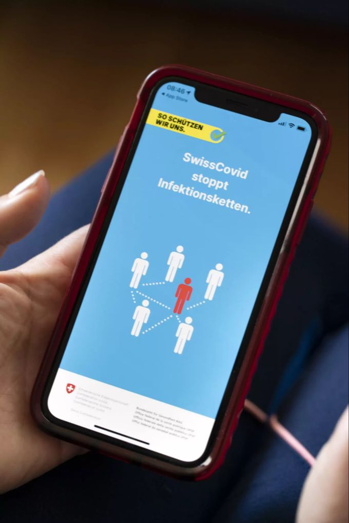 Eine Frau installiert die SwissCovid App auf ihrem Smartphone. corona app