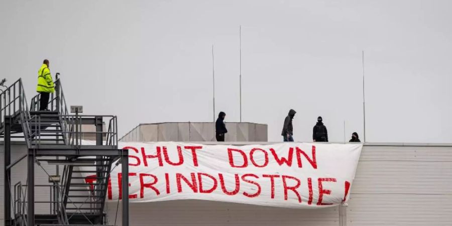 Aktivisten brachten auf dem Dach des Tönnies-Hauptstandorts in Rheda-Wiedenbrück ein Transparent mit der Aufschrift «Shut Down Tierindustrie» an. Foto: Guido Kirchner/dpa