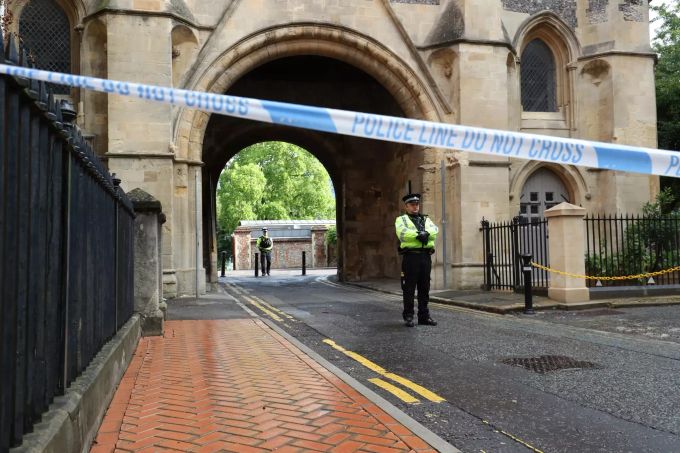 Polizisten stehen am Abbey Gateway von Forbury Gardens im Stadtzentrum von Reading hinter Absperrband nach einer Messerstecherei in Forbury Gardens. Vereinigtes Königreich