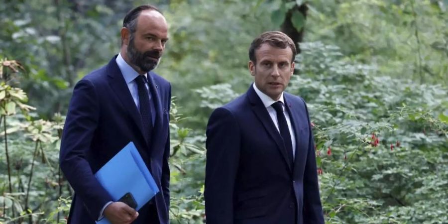 Frankreichs Präsident Emmanuel Macron (r) hat sich zu einer Volksabstimmung über Klimafragen bereit erklärt. Foto: Christian Hartmann/Pool Reuters/AP/dpa