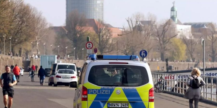 Die Polizei kontrolliert an der Rheinufer Promenade in Düsseldorf die Einhaltung der Vorsichtsmassnahmen. Foto: David Young/dpa