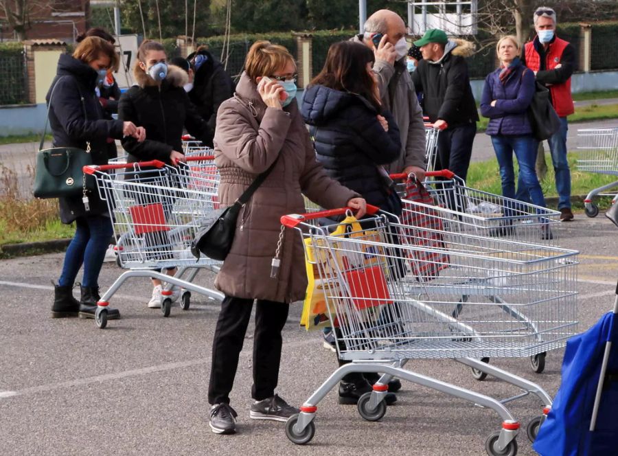 Italienische Kunden vor einem Supermarkt in Mailand.