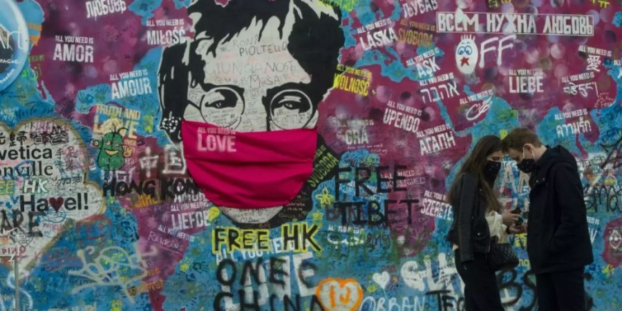 Ein Paar vor der John-Lennon-Mauer in Prag
