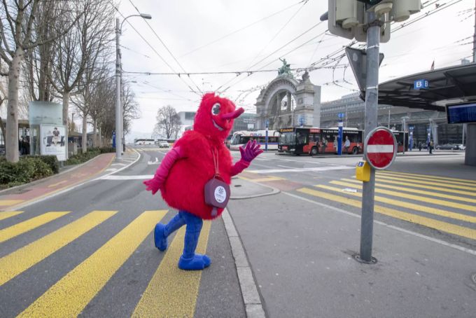 Maskottchen Wulli geht über die Strasse. maskottchen