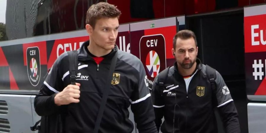 Will mit seiner Wadenblessur geduldig umgehen: Volleyball-Star Georg Grozer (l) verlässt mit Christian Fromm den Mannschaftsbus. Foto: Vdb / Bart Vandenbroucke/CEV
