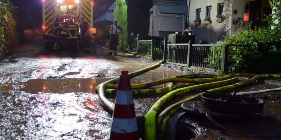 Feuerwehrleute pumpen einen Keller im Stadtteil Olewig leer. Foto: Harald Tittel