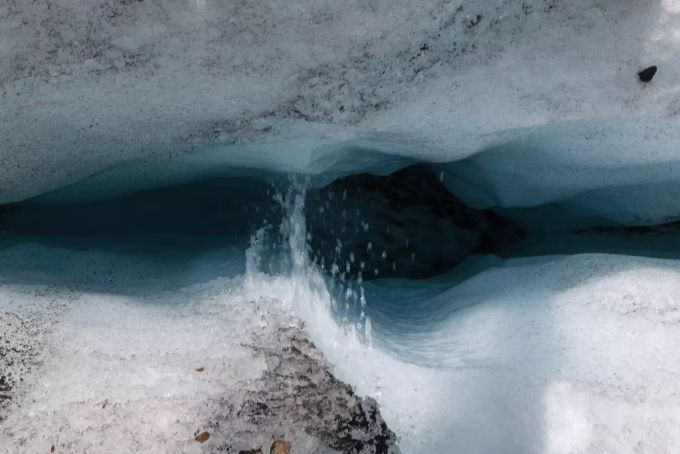 Schmelzwasser fliesst aus einem Gletscher. schmelzwasser
