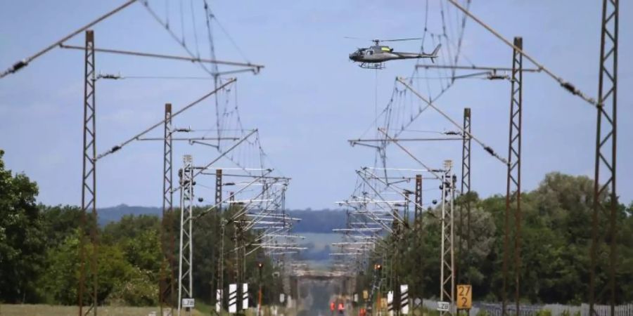 Ein Hubschrauber transportiert über der am Pfingstwochenende 2019 gesperrten Bahnstrecke Augsburg-Donauwörth einen Signalmasten der Bahn. Foto: Karl-Josef Hildenbrand