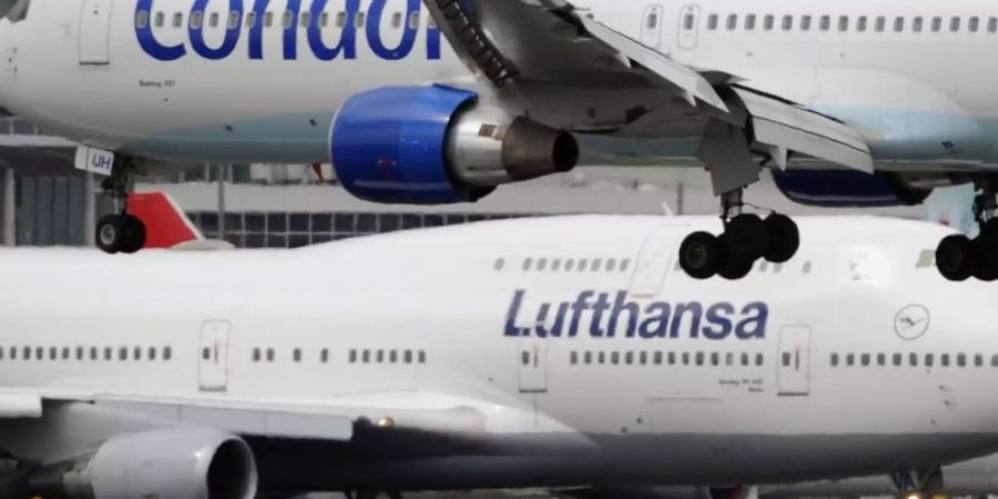 Eine Boeing 747 der Lufthansa rollt in Frankfurt zu ihrer Parkposition, während eine Boeing 757 der Condor gerade landet. Foto: Boris Roessler