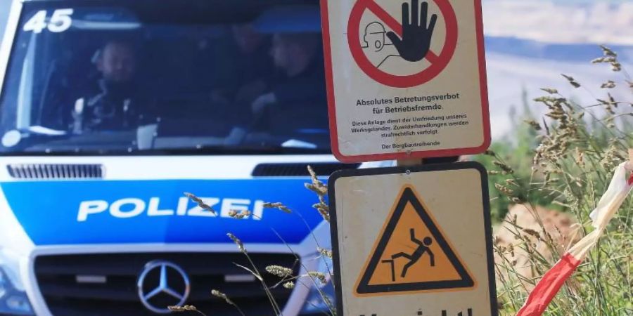 Polizeifahrzeug am Tagebau Garzweiler neben Warnschildern mit den Aufschriften «Werksanlagen». Foto: David Young