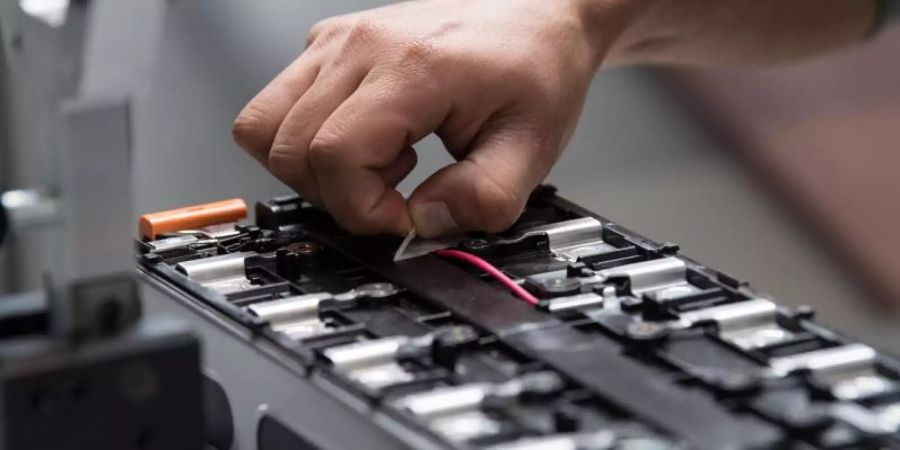 Ein Mitarbeiter arbeitet in der Batteriesystemfabrik von Akasol in Darmstadt an einer unfertigen Batterie. Foto: Fabian Sommer