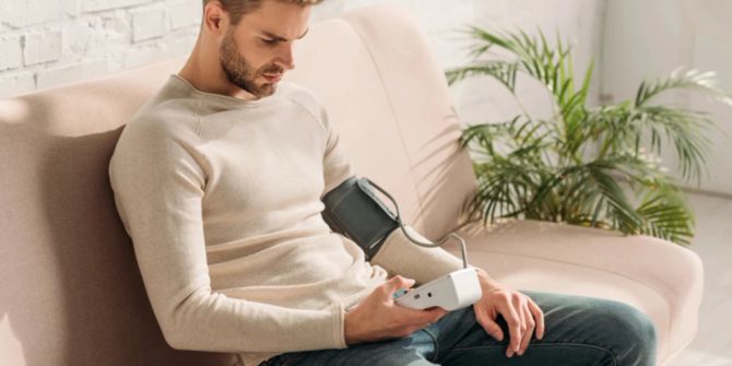 Mann Blutdruckmessgerät Couch