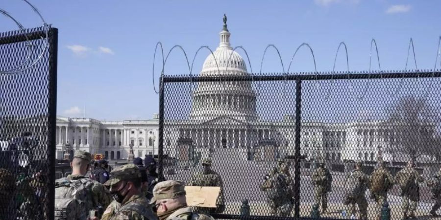 Soldaten der Nationalgarde gehen durch das Tor eines Sicherheitszauns vor dem Kapitol. Foto: Jacquelyn Martin/AP/dpa