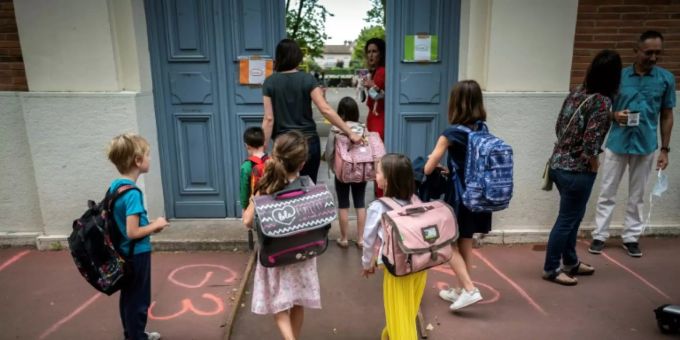 Kinder und Eltern vor einer Grundschule in Toulouse. frankreich corona