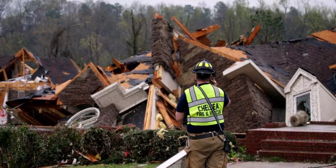 Ein Feuerwehrmann begutachtet Schäden an einem Haus, in dem die Familie gefangen war, aber in der Lage wurde, herauszukommen, nachdem ein Tornado südlich von Birmingham in der Gemeinde Eagle Point mehrere Häuser beschädigt hat. Unwetter in Alabama