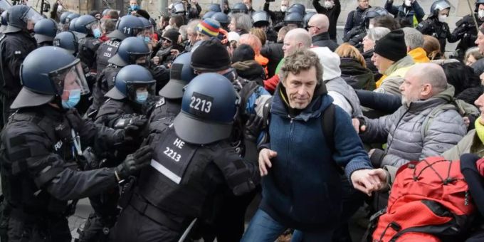 Einsatzkräfte der Polizei halten bei einer Kundgebung Teilnehmer zurück. Foto: Swen Pförtner/dpa Einsatzkräfte der Polizei halten bei einer Kundgebung Teilnehmer zurück. Foto: Swen Pförtner/dpa