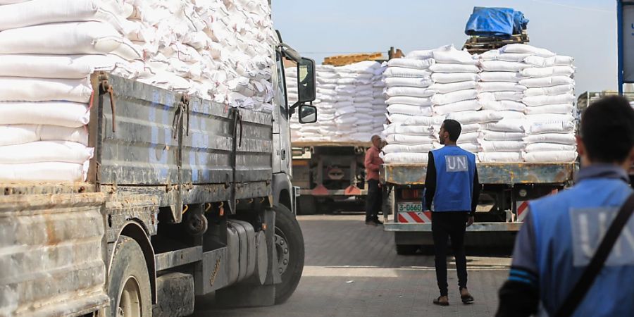 ARCHIV - Zwei Mitarbeiter laden Mehlsäcke auf einen Lastwagen im Verteilungszentrum des Hilfswerks der Vereinten Nationen für Palästinaflüchtlinge (UNRWA). Foto: Mohammed Talatene/dpa