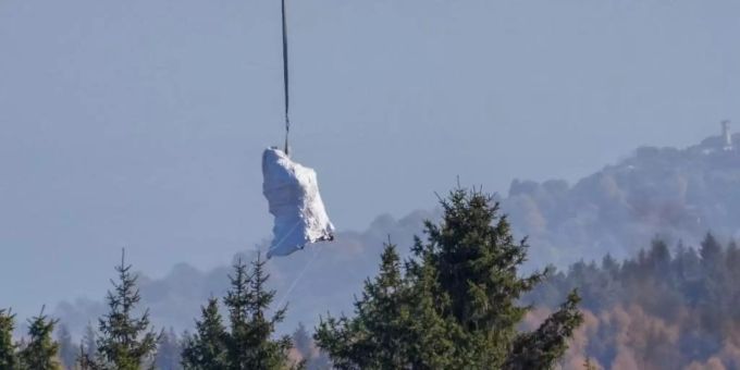 Ein Hubschrauber der italienischen Feuerwehr fliegt die in weisse Planen gehüllte Kabine der abgestürzten Mottarone-Seilbahngondel vom Lago Maggiore ins Tal. Foto: Antonio Calanni/AP/dpa Ein Hubschrauber der italienischen Feuerwehr fliegt die in weisse Planen gehüllte Kabine der abgestürzten Mottarone-Seilbahngondel vom Lago Maggiore ins Tal. Foto: Antonio Calanni/AP/dpa