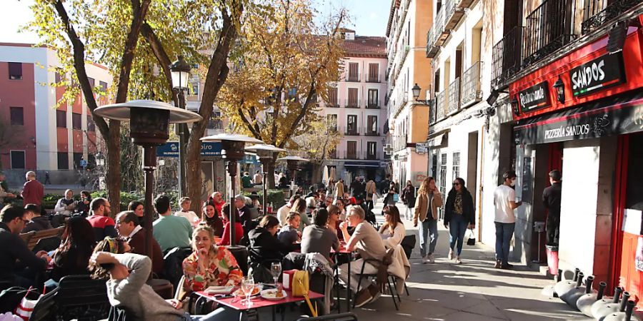 PRODUKTION - Menschen sitzen auf der Terrasse einer Bar im Zentrum von Madrid. Foto: Juan Carlos Rojas/dpa