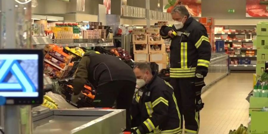 Einsatzkräfte der Polizei, Feuerwehr und ein Spinnenexperte suchen in den Obst- und Gemüseregalen des Supermarktes nach dem Tier. Foto: Nord-West-Media/Nord-West-Media /dpa
