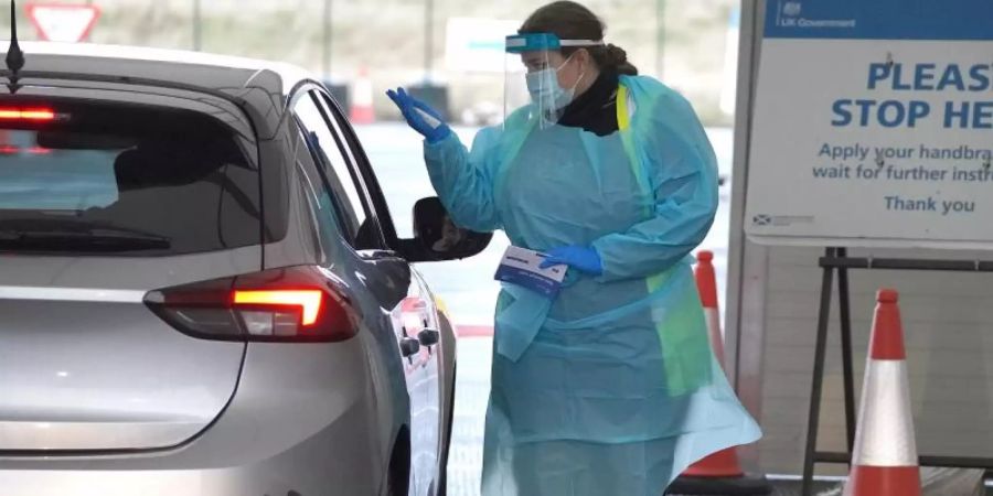 Eine Medizinerin entnimmt einem Bürger eine Probe auf dem Corona-Testgelände am Flughafen Edinburgh. Foto: Andrew Milligan/PA Wire/dpa