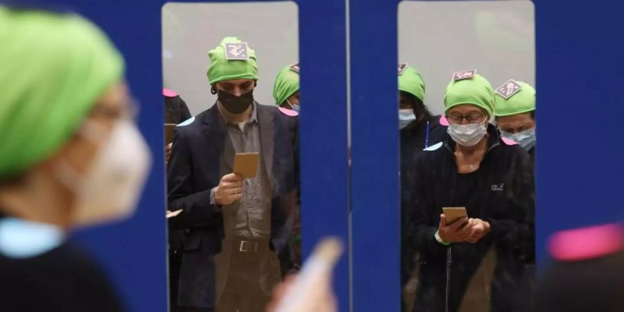 Probanden, mit grünen Mützen und Punkten zur Kameraerfassung markiert, simulieren im Rahmen eines Fussgänger-Experiments den Ein- und Ausstieg am Bahnsteig. Foto: Oliver Berg/dpa