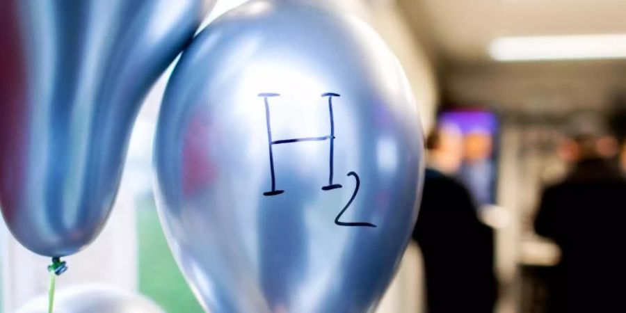 Ballons mit der chemischen Formel für Wasserstoff «H2» hängen im «Microgrid»-Testlabor, das in einem Container vor der Hochschule Bremerhaven untergebracht ist. Foto: Hauke-Christian Dittrich/dpa