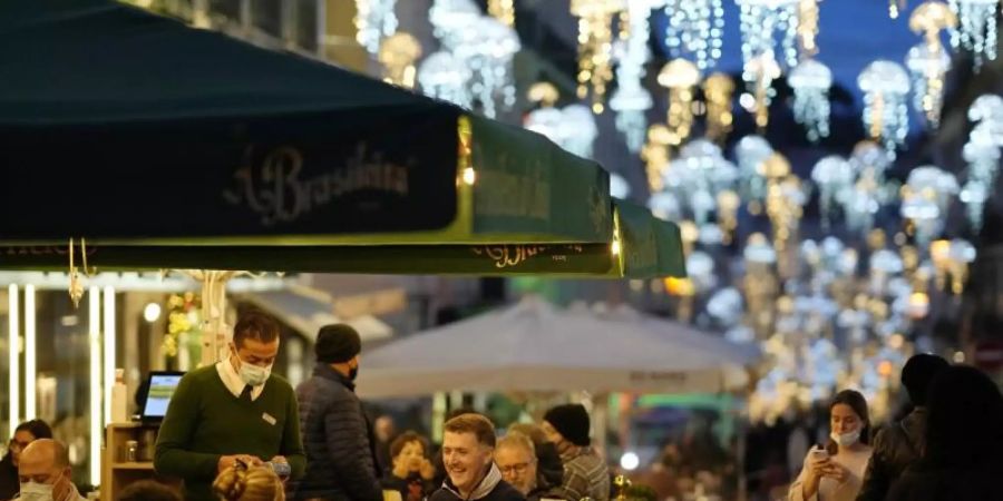 Auch im Winter kann man in Lissabon draussen sitzen. Foto: Armando Franca/AP/dpa