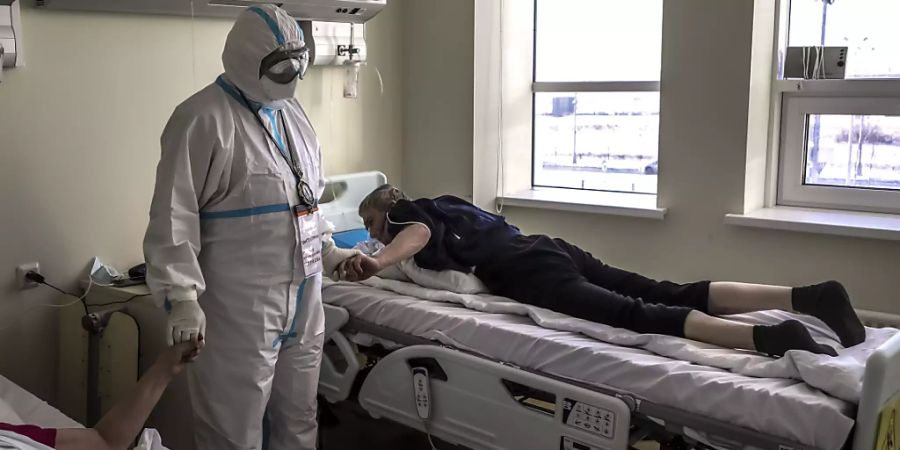 dpatopbilder - Der Bischof (M) der Russisch-Orthodoxen Kirche, Panteleimon, tröstet Patienten, die im Verdacht stehen, das Coronavirus zu haben, in einem Krankenhaus in Kommunarka, ausserhalb von Moskau. Foto: Sophia Sandurskaya/Moscow News Agency/dpa