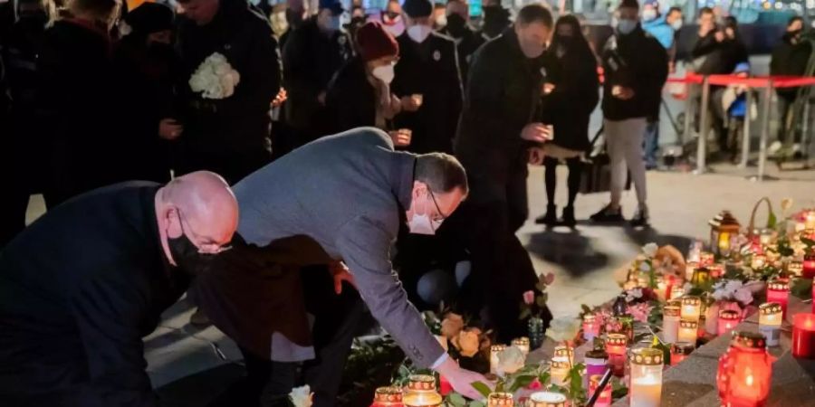 Michael Müller (SPD, M), Regierender Bürgermeister von Berlin, und Edgar Franke (SPD), Opferbeauftragter der Bundesregierung, legen bei einer Gedenkfeier am vierten Jahrestag des islamistischen Anschlags auf den Weihnachtsmarkt am Breitscheidplatz Kerzen nieder. Foto: Christoph Soeder/dpa