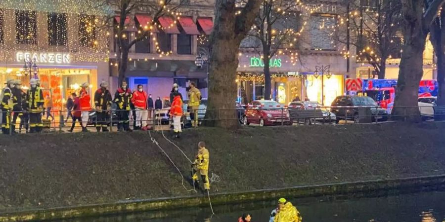 Einsatzkräfte helfen dem Mann aus dem «Kö»-Graben. Foto: Oliver Auster/dpa