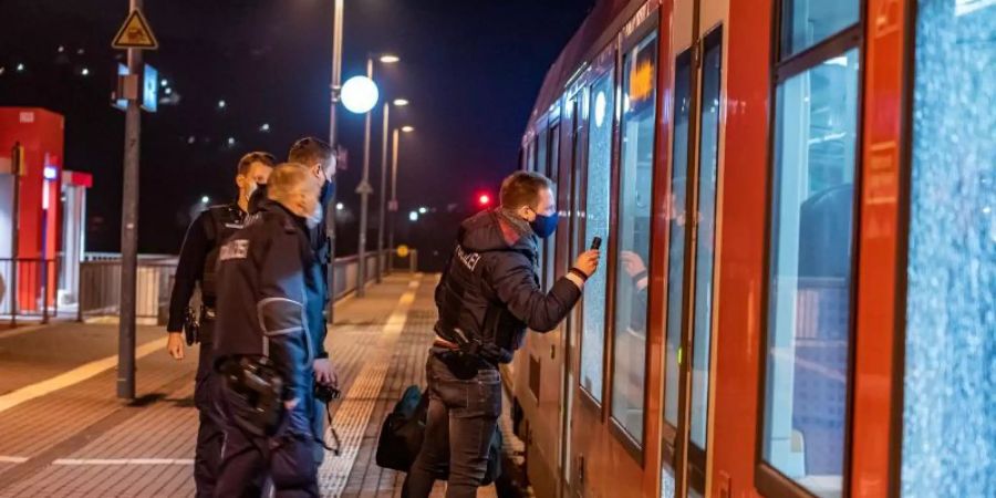 Einsatzkräfte der Polizei untersuchen die betroffene Regionalbahn. Foto: Markus Klümper/dpa