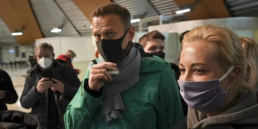 An der Passkontrolle ist Kremlkritiker Alexej Nawalny (M) - hier mit seiner Frau Julia - abgeführt worden. Foto: Mstyslav Chernov/AP/dpa